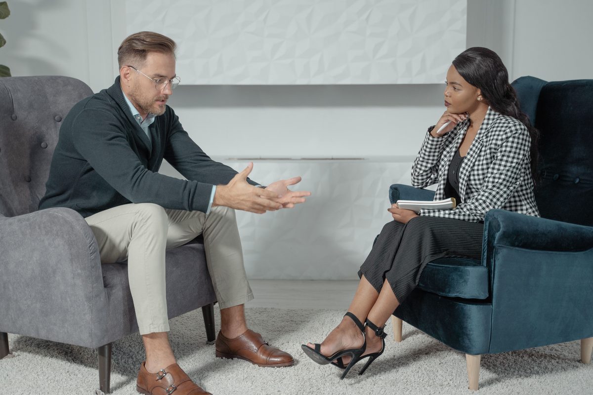 A clinician listening closely to a patient during a one-to-one conversation